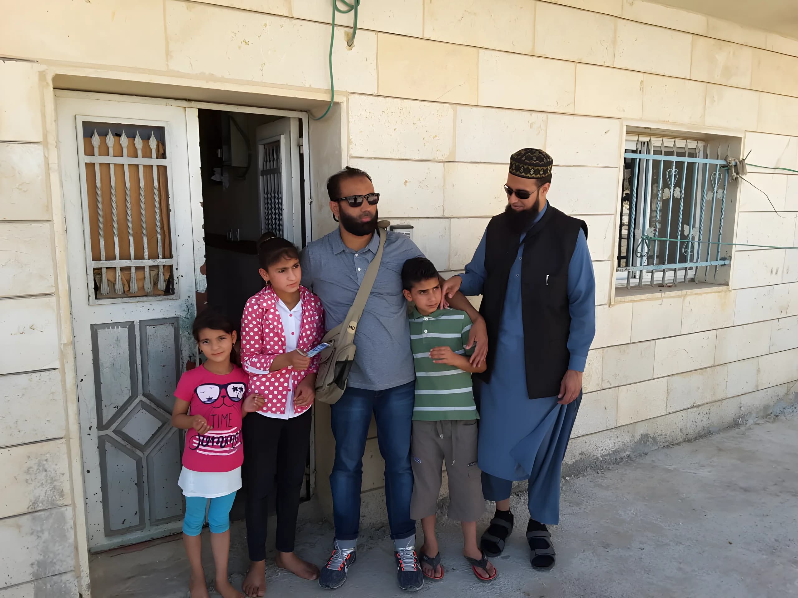 Gruppe samlet utenfor en bolig i Palestina